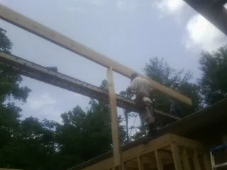 Carpenter setting a ridge beam over a new addition frame — Ice Dam Removal by Roofing Brothers in Estes Park