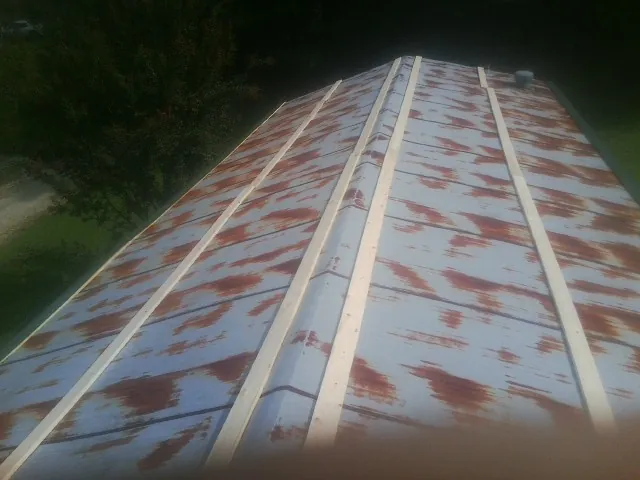 Rusted metal roof panels with new wood purlins before replacement — Storm Damage Roof Repair in Estes Park by Roofing Brothers