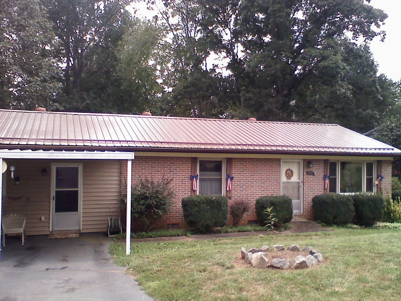 Bronze metal roof and carport on a brick ranch home — Roof Repair work by our crew in Estes Park